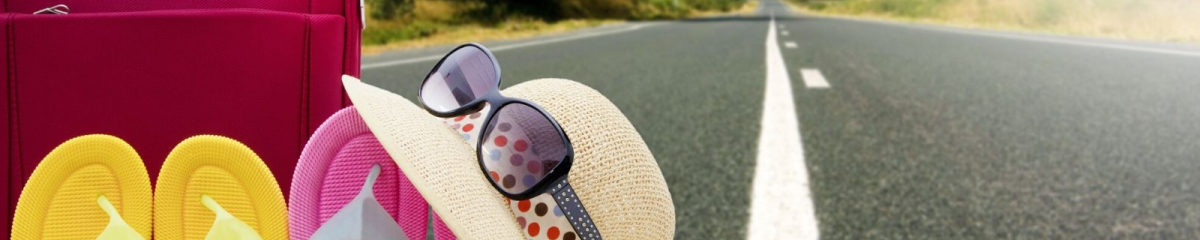 a road with a suitcase, hat, sunglasses and shoes as if ready for a trip